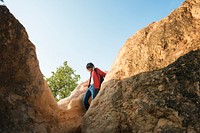 A guy climbing through rocks