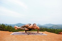 Man doing yoga on a cliff