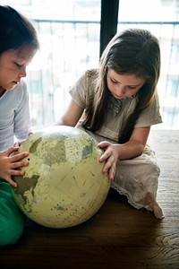 Little girls playing with a globe