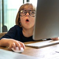 Young girl with glasses shocked from using a computer