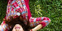 Indian woman is lying on the green grass
