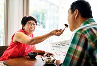 Elderly Senior Couple Playful Feeding Cafe Concept