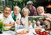 Group of old people having dinner taking a photo
