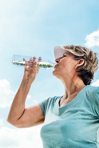 Senior woman drinking water after an exercise