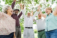 Group of happy retired senior friends  in the park cheering