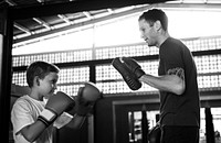 Young boy boxing with his teacher