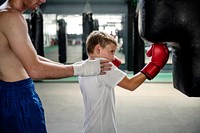 Young boy boxing with his teacher