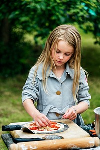 Little girl preparing a pizza