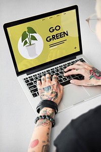 Tattooed hands going green on laptop