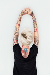 Tattooed blonde woman stretching her arms