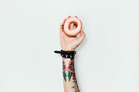Tattooed woman holding a donut