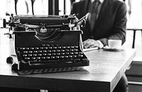 Black and white image of a vintage typewriter and a businessman