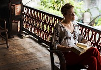 Caucasian woman reading the book at the balcony