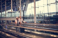 Senior couple traveling airport travelator scene