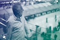 Man staring at the airport crowd downstairs