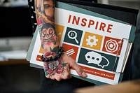 Tattooed hand with different icons on a clipboard