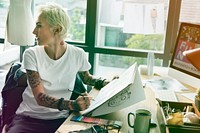 Fashion designer tattooed girl drawing cloth pattern