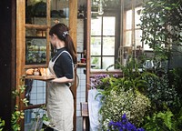 Woman holding a tray with bread in a flower shop