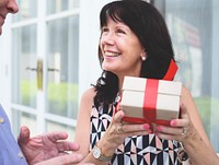 Woman holding a box of present with red bow