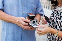 Couple printing a photo on instant camera