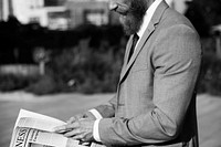 Business man reading a newspaper outdoors black and white