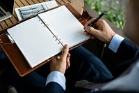 Businessman writing on a personal notebook copyspace
