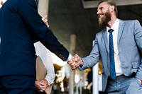 A businessman and a businesswoman shaking hands in agreement