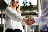 A businessman and a businesswoman shaking hands in agreement