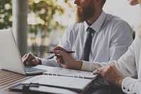 Business people collaborating using a laptop and a notebook