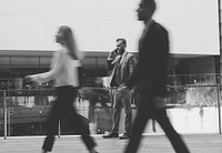 Business people walking outdoors and a businessman on the phone focused