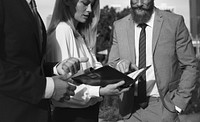 A businessman and a businesswoman pointing at a notebook and discussing