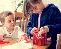 Little Children Wrapping Present Smiling