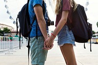 Couple holding hands in an amusement park