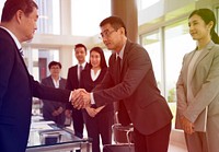 Business people greeting by handshake and take a bow