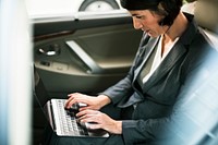 Businesswoman Working Using Laptop Car Inside