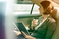 Businesswoman using digital tablet on backseat of the car