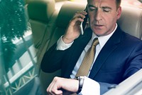 Businesswoman on the phone on backseat of the car