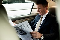 Businessman reading a newspaper in a car