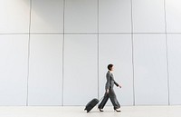 Businesswoman walking with her luggage in tow