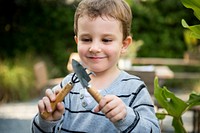 Cute young boy playing with gardening tools