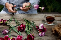 Florist hands trimming flower leaves 