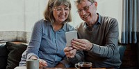 Old couple using mobile phone together