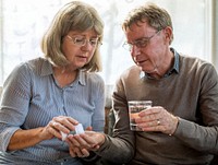 Old woman giving her husband pills