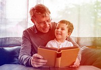 Grandfather and little cute grandson reading book together