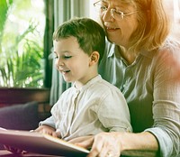 Grandmother and little cute grandson reading book together