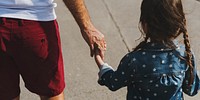 Daughter holding her dad's hand while walking