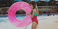 Little girl with a summer float by the pool