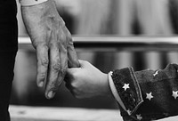 Grayscale closeup of daughter holding father's hand