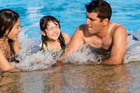 Mixed family enjoying summer pool time