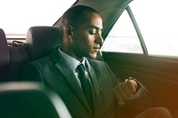 Businessman sitting on the back seat looking watch